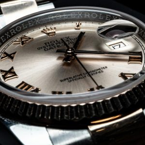 Detailed close-up of a luxury Rolex wristwatch displaying its elegant design and date feature.