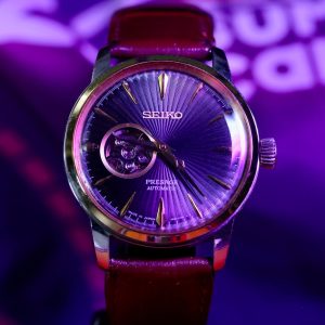 Purple and red-themed photo of luxury Seiko Presage watch, emphasizing elegance.