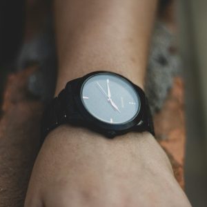 Minimalist black watch on wrist showcasing elegant design and precise timekeeping.